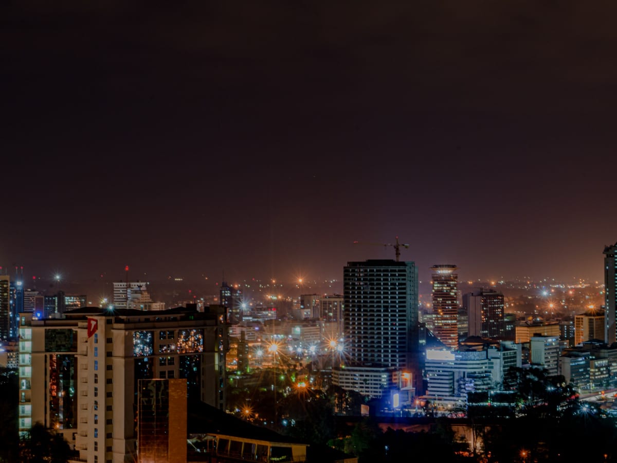 The Nairobi skyline at dusk under a violet sky.