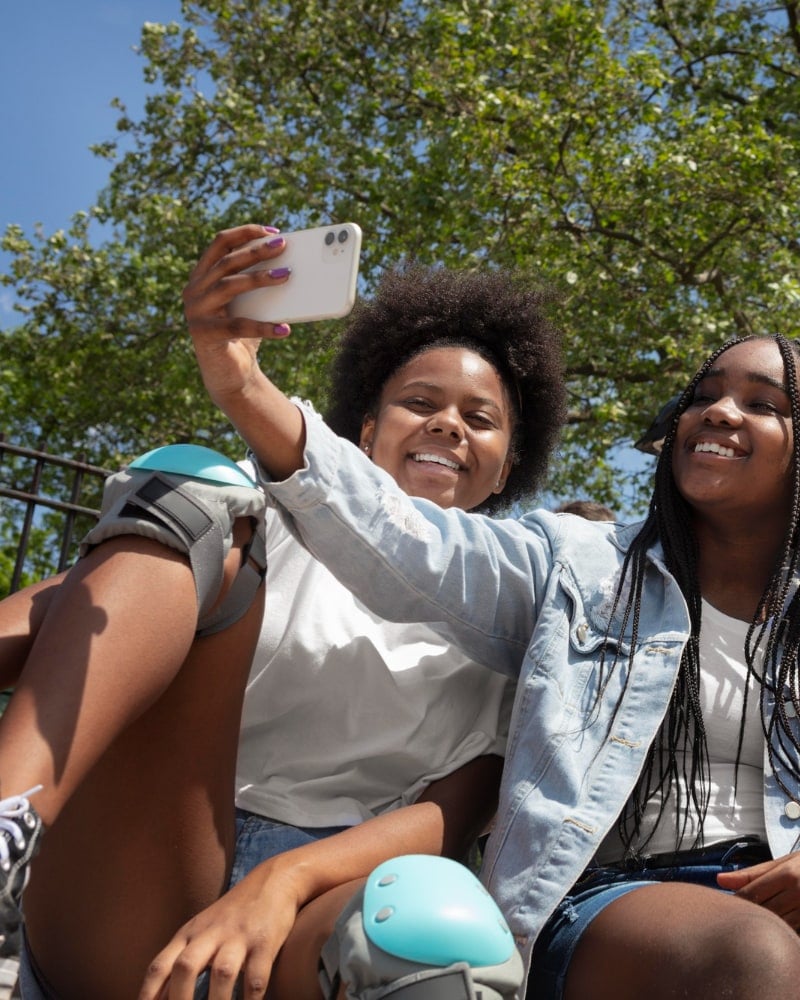 Friends taking a selfie together in a park.